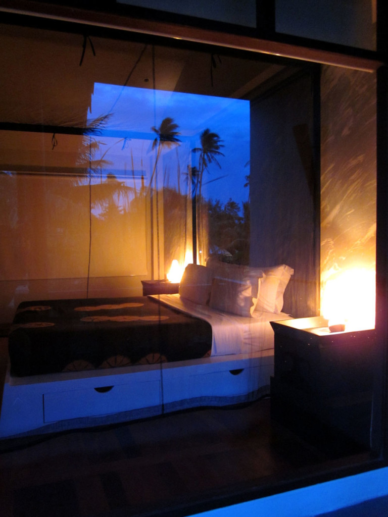 The Deluxe Balcony at the Muang Kulaypan beach resort. A view from the balcony’s wide day bed with coconut palms reflecting in the window. photo: the art resort.